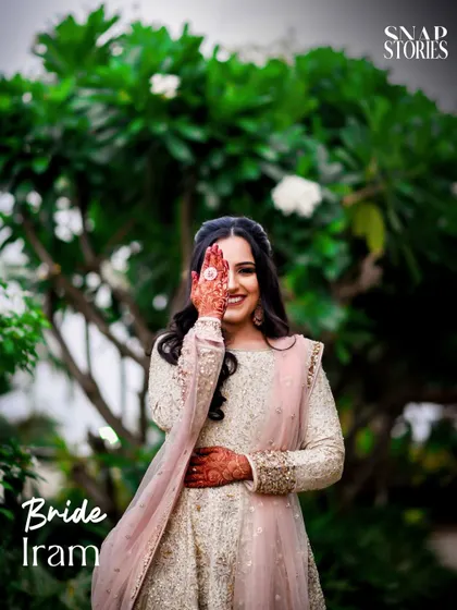A playful and charming portrait of the bride, with her henna-covered hand partially covering her face. We love capturing our brides' personalities in their portraits.