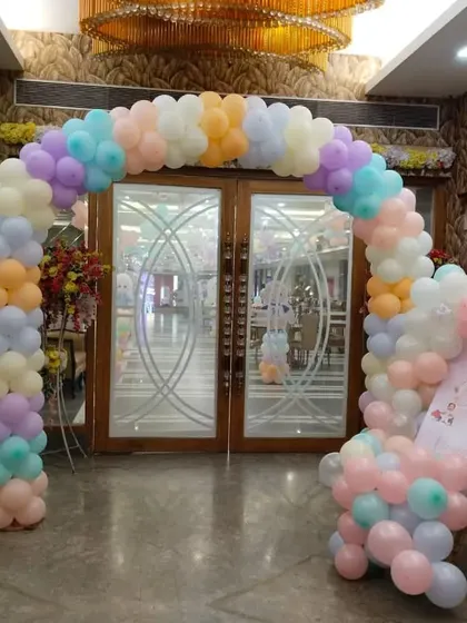 A pastel-colored balloon arch at the entrance of a party venue. This soft and inviting entrance is perfect for a first birthday or a baby shower.