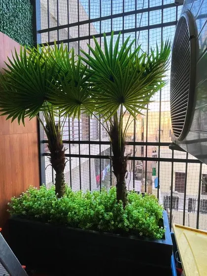 To create a tropical feel and add privacy, we installed these artificial palm trees in a sleek, modern planter. This is a great low-maintenance solution for sunny balconies.