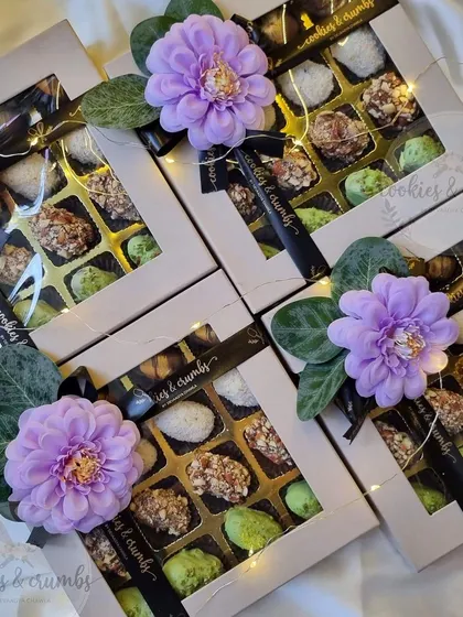 My assorted chocolate and stuffed date boxes ready for Diwali. Each box is decorated with a beautiful purple flower, making it a lovely gift.