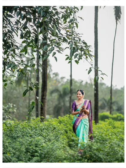 A graceful bridal portrait, with the bride walking through a green landscape, surrounded by tall trees.