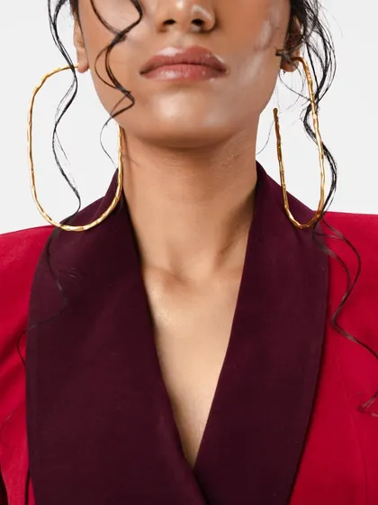 A close-up of the wet-look hairstyle. You can see the individual strands sculpted around the face, adding an artistic and edgy texture to the overall look.