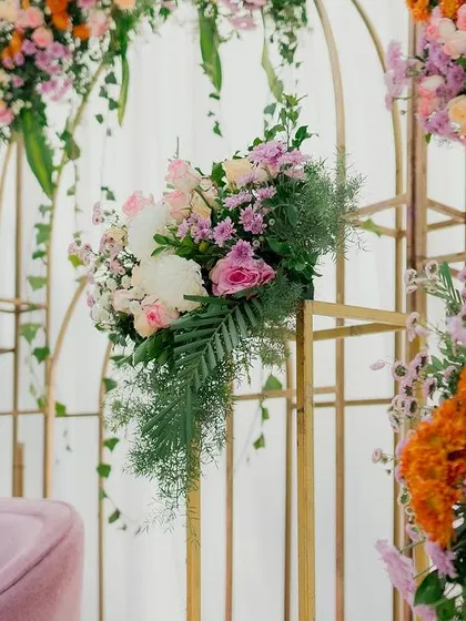A detailed shot of the floral arrangements on our modern golden arches. We use a mix of roses, chrysanthemums, and fresh greenery to create a lush, multi-dimensional look.