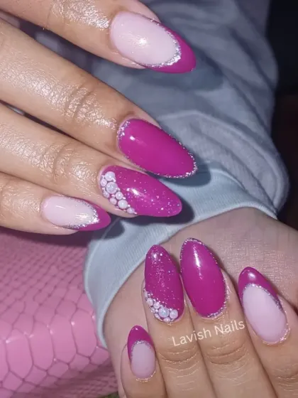 A vibrant magenta manicure featuring a modern French tip outlined in silver glitter and an accent nail with a cluster of white pearls.