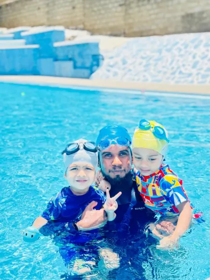 A coach with two young swimmers, showcasing our ability to manage small groups effectively while giving each child the attention they need to feel safe and confident.
