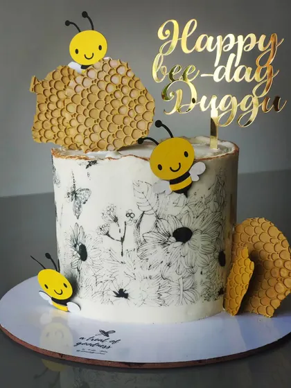 A "Happy Bee-day" cake with a beautiful, hand-stenciled wildflower and butterfly pattern. I added cute bee and honeycomb accents to complete the theme.