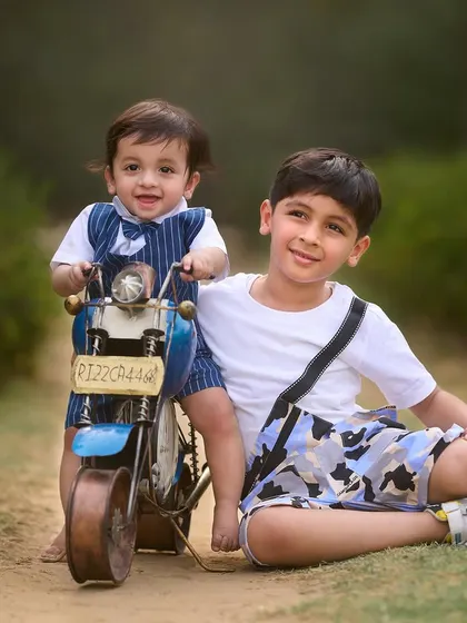 Big brother showing his little brother the ropes. I love incorporating props like this toy motorcycle into sibling photoshoots to create fun, interactive scenes.