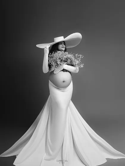 The same portrait in timeless black and white. The monochrome edit emphasizes the textures of the fabric and the classic, statuesque pose of the mother-to-be.
