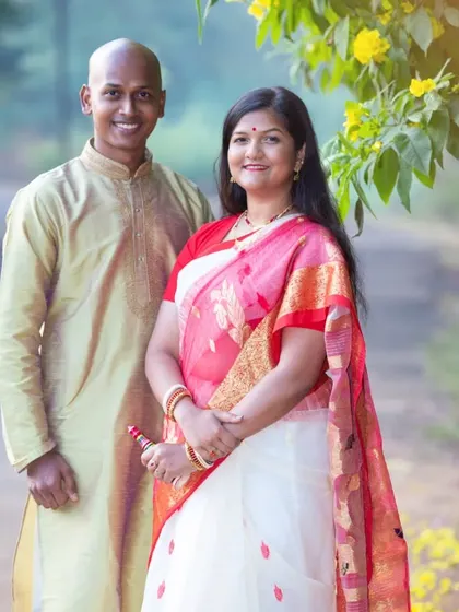 A pre-wedding portrait of a Bengali couple in a natural, outdoor setting, dressed in traditional attire.