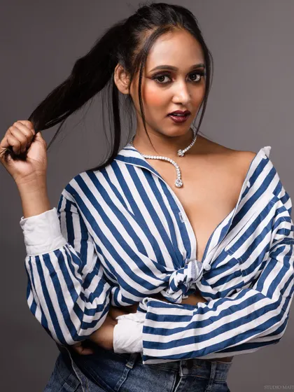 A direct-to-camera portrait in the striped shirt, with a strong and engaging gaze.