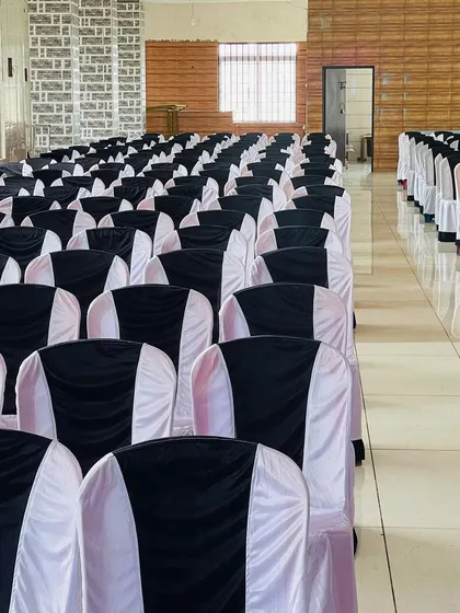 Neatly arranged seating with black and white chair covers at Ahmed Palace. We ensure the seating arrangement is clean and orderly before the guests arrive.