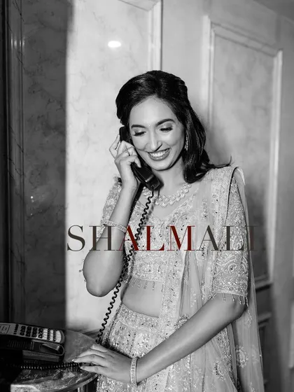 A classic black and white portrait of the bride smiling while on a vintage telephone. This shot has a timeless, elegant feel, highlighting her joy and beauty.