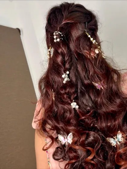 A whimsical and romantic hairstyle for a Mehendi or Haldi function, adorned with delicate pearls and butterfly clips.