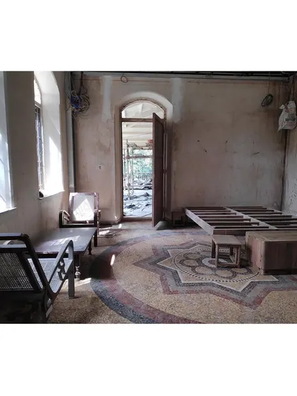 An early "before" shot of a room during the restoration process, with the original mosaic floor and inherited furniture pieces that served as our starting point.