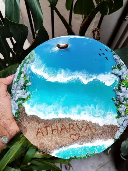 Holding the 'Atharva' resin art piece against a backdrop of green leaves. The natural elements in the background complement the nature-inspired theme of my artwork.