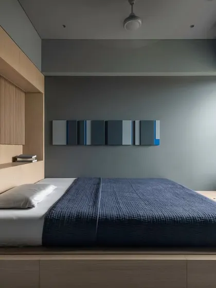 The third bedroom, featuring a platform bed with an integrated light oak headboard and a pop of blue in the bedding.