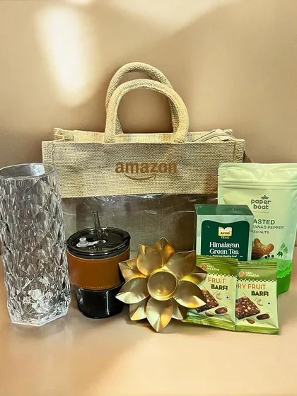 For this corporate order for Amazon, I used a branded, eco-friendly jute bag. Inside, recipients found a crystal vase, a personalized tumbler, healthy snacks, and a lotus tea light holder for a thoughtful Diwali gift.