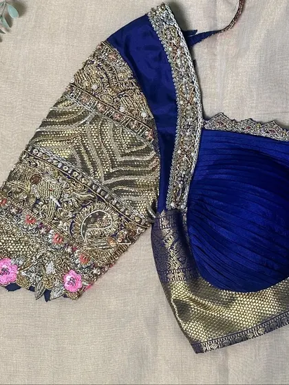 A royal blue draped blouse hand-embroidered with zardozi.