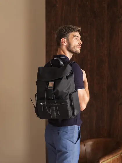A shot for Moral Code footwear, identical to 150, focusing on a versatile backpack. The styling demonstrates how the accessory fits into a smart-casual, modern lifestyle.