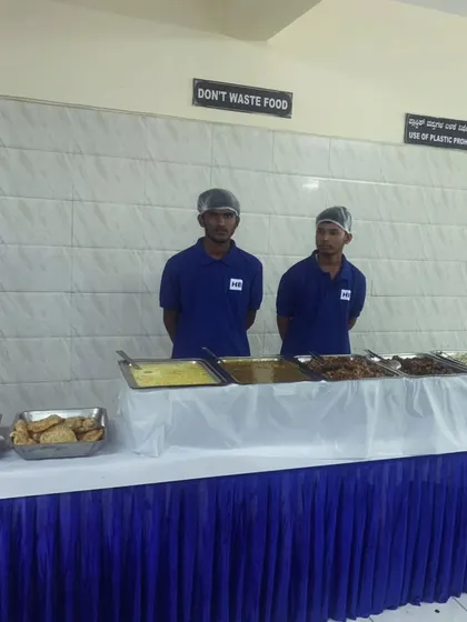 Our professional staff ready to serve at a neatly arranged buffet table, with a sign "Don't Waste Food" reflecting our values.