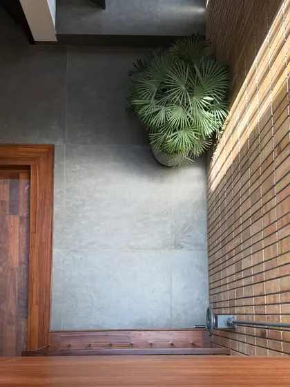 An overhead view showing the combination of materials: the warmth of wood, the coolness of grey tile, and the texture of a brick wall.