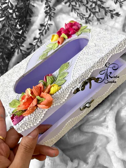 An angled view of the lavender tissue box, showing the side details and the clasp mechanism.