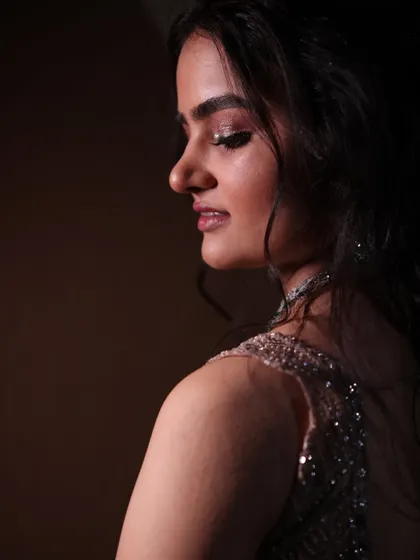 A side profile showcasing the soft, glowing highlight on the cheekbones and the subtle shimmer on the eyelids. This is modern elegance at its best.