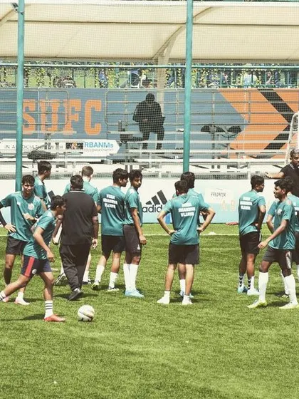 A team huddle during a practice session at the Bangalore Football Stadium. Our coaches use these moments to provide tactical instruction and ensure the team is aligned.