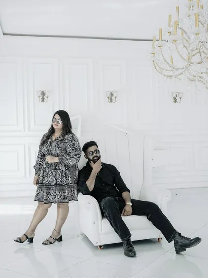 A playful yet stylish pose in the all-white room, showcasing the couple's personality.