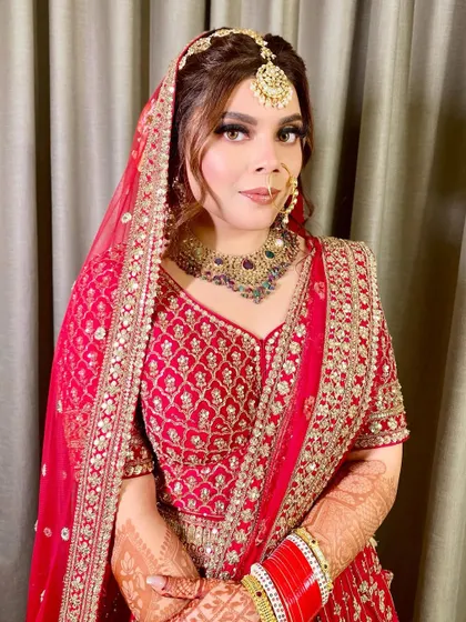 A close-up of the gorgeous Lavanya. Her bridal makeup features a soft smokey eye and a neutral lip, allowing her stunning red outfit and jewelry to take center stage.