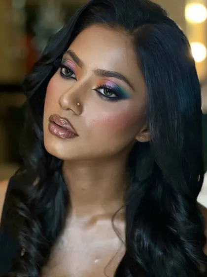 A close-up of the colourful eye makeup on melanin-rich skin. The colours are bold and blended seamlessly, creating a stunning peacock-like effect.