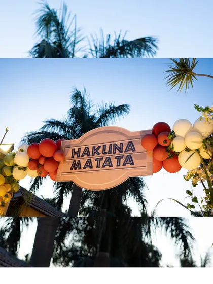 A "Hakuna Matata" sign framed by a sunset-colored balloon arch against a backdrop of palm trees perfectly captured the carefree spirit of The Lion King.
