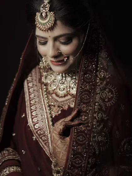 A graceful portrait of the bride looking down, her hand gently touching her necklace. This pose is elegant and timeless.