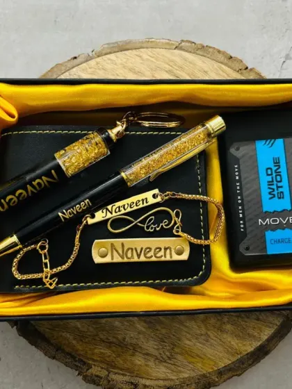 This Rakhi hamper features multiple personalized items including a wallet, pen, keychain, and bracelet, all with the name 'Naveen'. It's paired with a Wild Stone perfume.