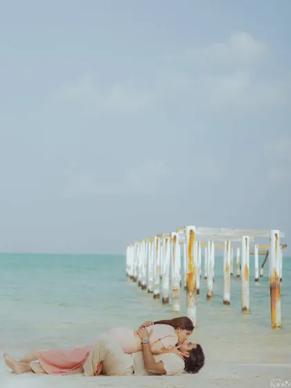 A serene moment on the white sands of Lakshadweep, with the iconic pier stretching into the turquoise sea. This wide shot emphasizes the beauty and seclusion of the destination.