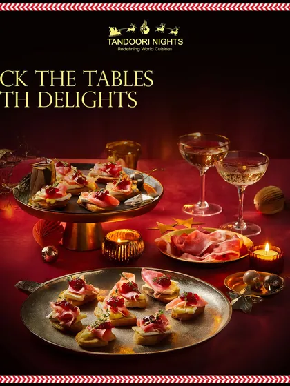 Deck the tables with delights. This image captures a festive Christmas spread with canapés and champagne, set in a warm, candlelit ambiance.