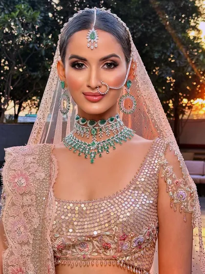 A beautiful sunset-hued bridal look. This image showcases how to work with a monochromatic color palette, matching the makeup tones to the outfit for a cohesive and sophisticated result.