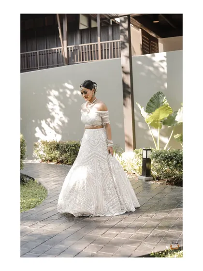 A full-length portrait of the bride in her stunning white lehenga at her Thailand wedding.