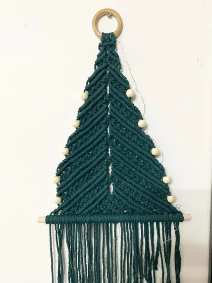 Here is the macrame Christmas tree wall hanging without the lights. It's made with dark green cotton cord and is a beautiful, minimalist decoration.