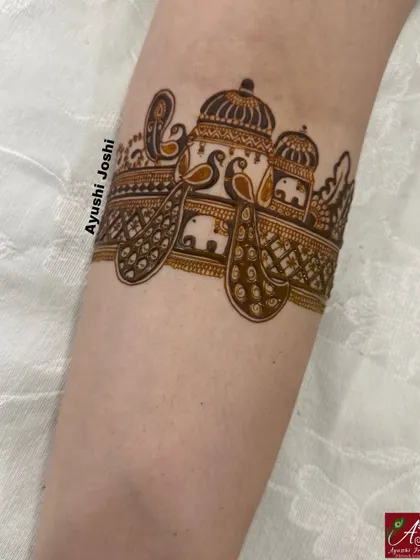 This arm band combines majestic peacocks and elephants in a design fit for a queen.