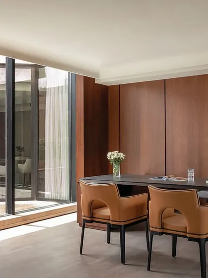 We tailor executive spaces to individual tastes, like this director's cabin in The Layered Office, which offers prime views of a landscaped terrace and features bespoke wood paneling and curated furniture.