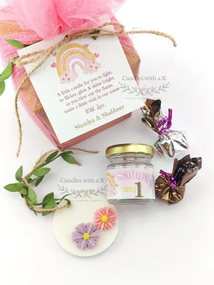 The complete rainbow-themed gift set, showing the personalized tag, candle, sachet, and chocolates.