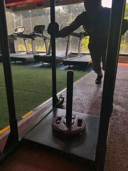 A silhouette of a client pushing the sled, emphasizing the raw power and effort involved in this exercise.