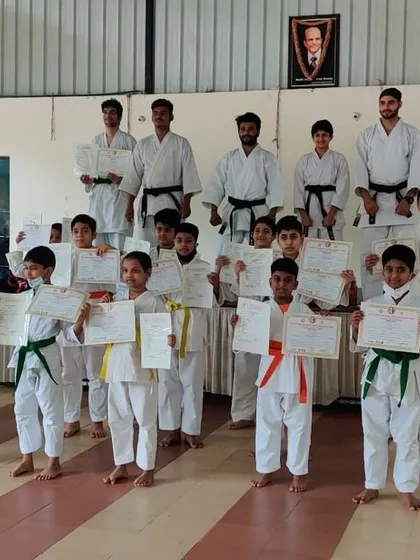 Students from our second batch pose with their certificates after completing their belt test. The different colored belts show the range of skill levels within the group.