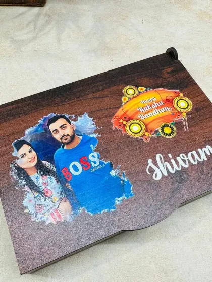 The personalized wooden box for a Rakhi hamper, featuring a custom photo of the siblings and the brother's name, 'Shivam'.