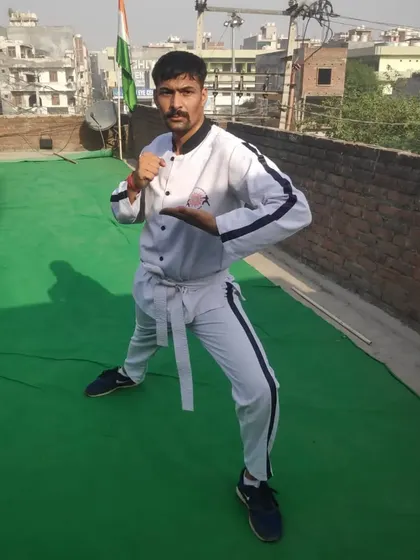 Green Belt student Shrikant Hudda in a ready stance on the rooftop. Training happens everywhere, with the Indian flag proudly in the background.