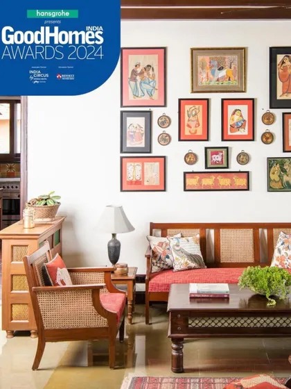 I believe a home should be a gallery of personal stories. In this seating area, a collection of traditional Indian art is displayed above a classic cane and wood sofa, creating a corner that is rich with culture and memory.