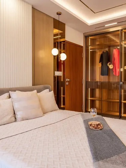 Another angle of the bedroom with the glass-fronted wardrobe, showing how it reflects light and adds a sense of openness to the space.