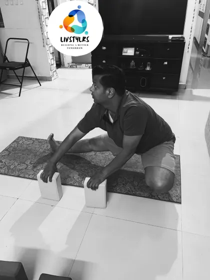 A client uses blocks to support a wide-legged forward fold, allowing for a deeper and more restorative stretch.