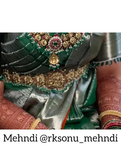 A close-up of the bride's arms, showing the beautiful, even stain of her full-arm mehndi. The details of the design are crisp and clear.